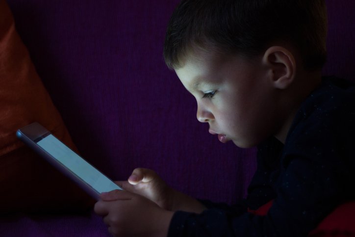 Cute kid with tablet in the dark