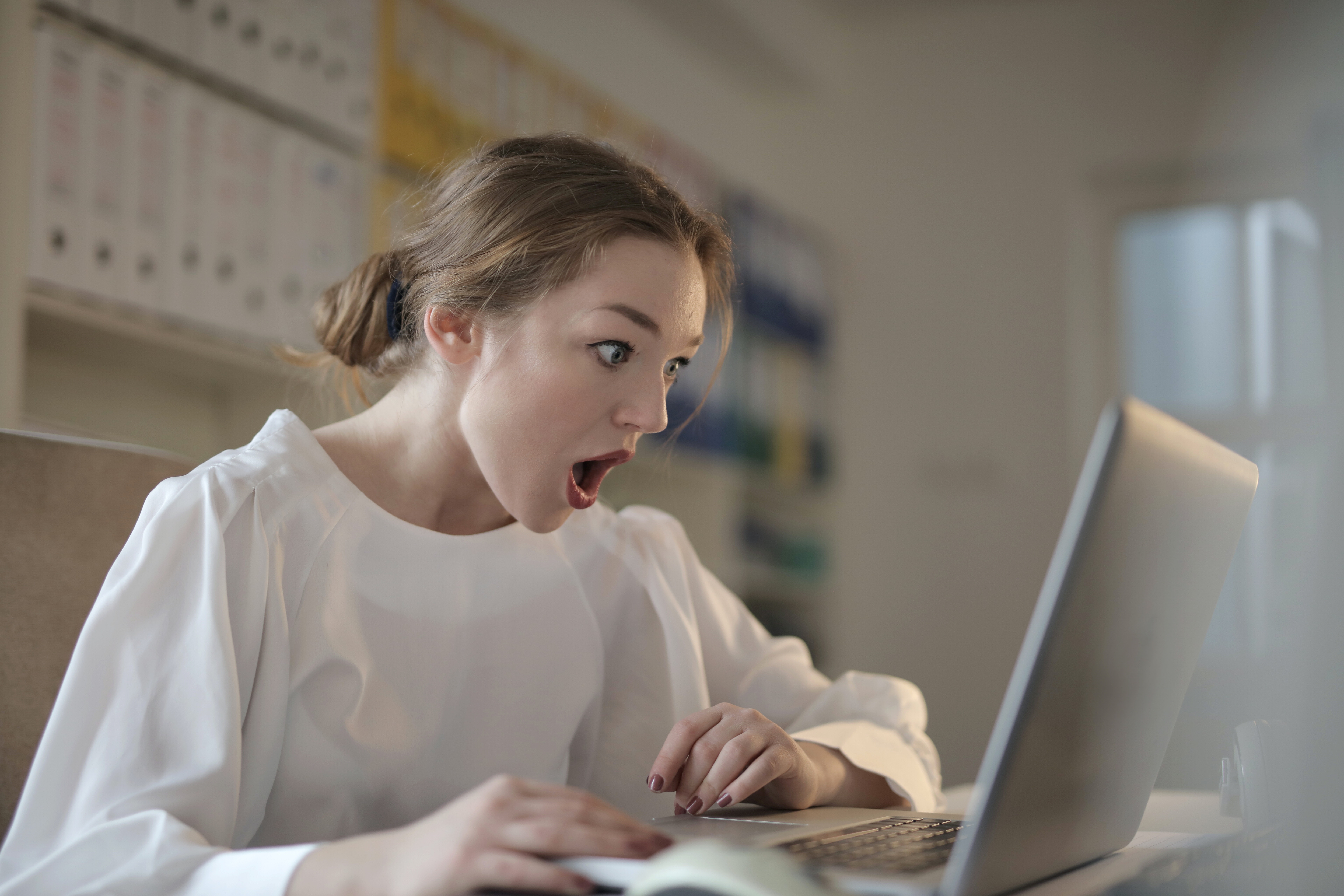woman looking at computer with shocked expression