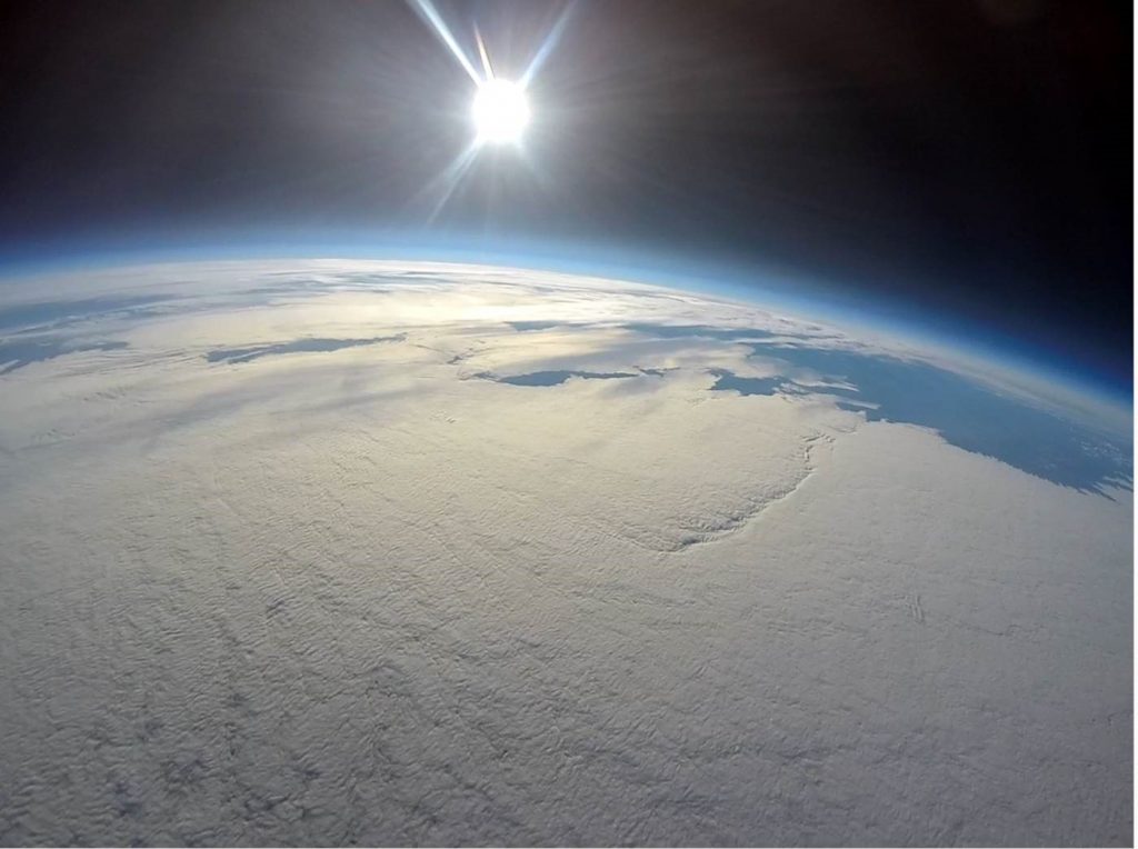 image of earth and distant sun from space