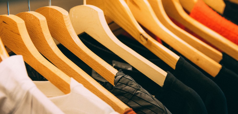 several multi-colored shirts on hangers